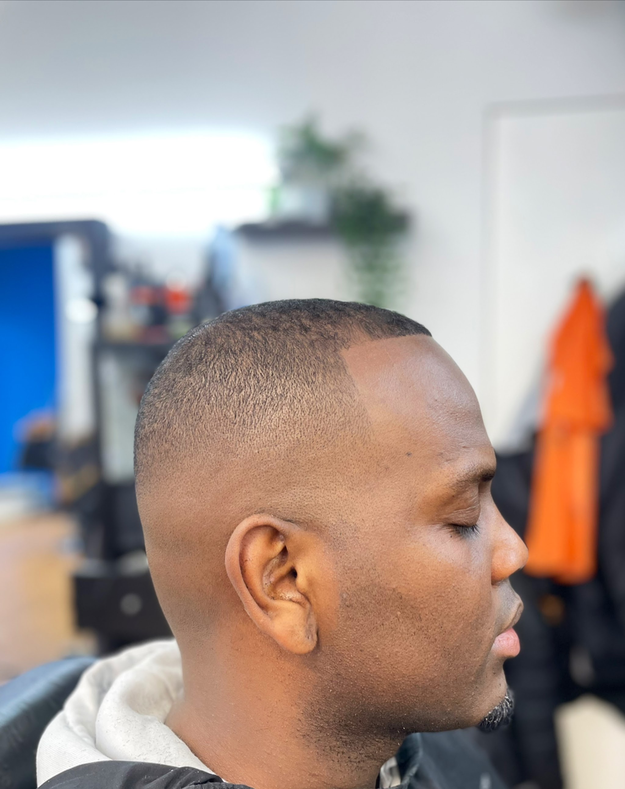 Gladde skin fade met een kort bovenhaar, van opzij
